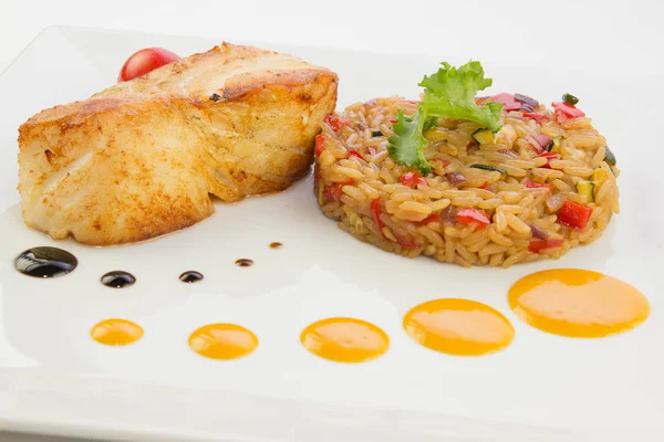 Chilean fish sea bass with a rice and tomato — Stock Photo, Image
