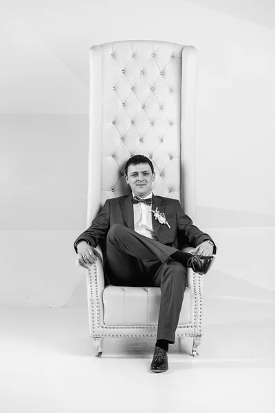 Preto e branco retrato de bonito homem posando no estúdio no braço — Fotografia de Stock