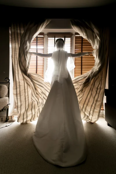 Tonificado disparo de la novia joven abriendo cortinas en la habitación del hotel —  Fotos de Stock
