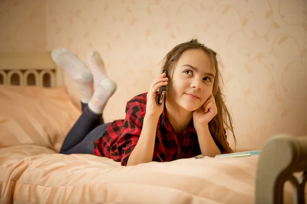 Yatak odasında yalan ve telefonla konuşan genç kız — Stok fotoğraf