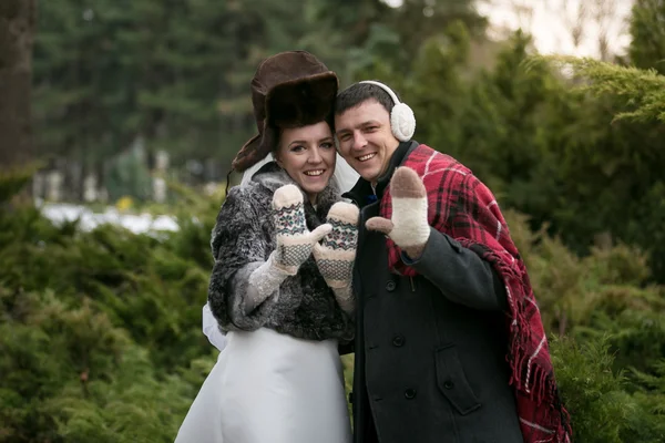 Retrato de pareja recién casada en bufandas y sombreros posando en w — Foto de Stock