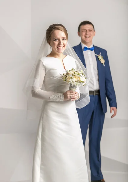 Glücklich lächelnde Braut posiert mit weißen Rosen im Studio — Stockfoto