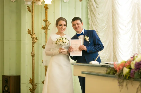 Kayıt defteri ofisinde düğün con ile poz yeni evliler portresi — Stok fotoğraf