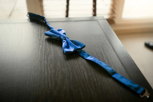 Nahaufnahme einer blauen Seidenfliege, die auf einem hölzernen Nachttisch liegt — Stockfoto