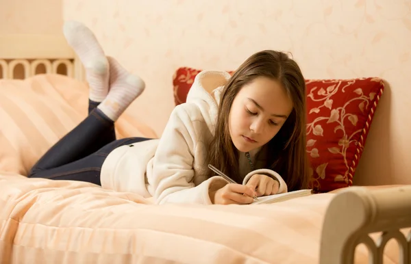 Teenage girl making notes in personal diary — Stock Photo, Image