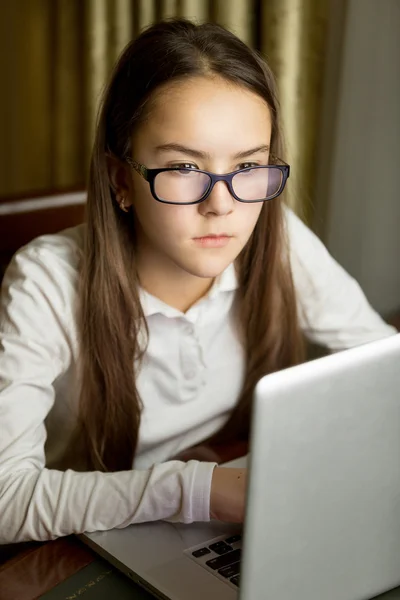 Retrato de bela menina adolescente em óculos usando laptop — Fotografia de Stock