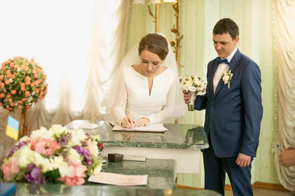美丽的新娘签署结婚许可证在注册表的肖像 — 图库照片