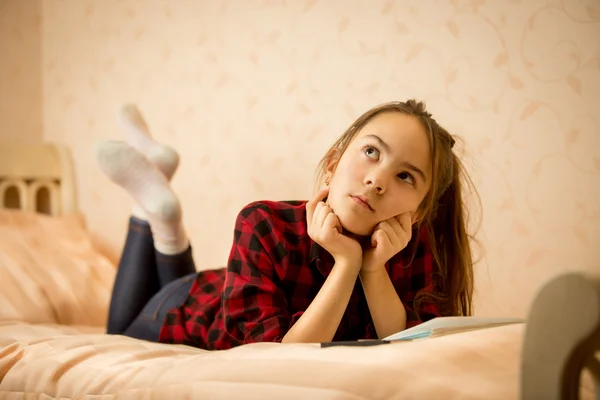 Nachdenkliches Teenager-Mädchen liegt auf Bett — Stockfoto