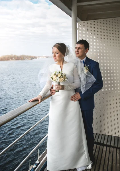 Smiling newly married couple looking at river from hotel room — Stock Photo, Image