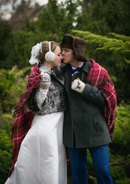 Feliz casal recém-casado beijando na floresta de inverno — Fotografia de Stock