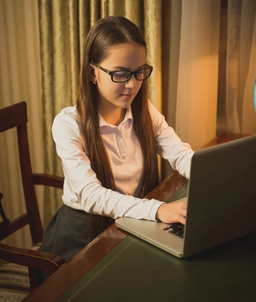 Retrato de menina adolescente em camisa branca datilografando mensagem no comput — Fotografia de Stock