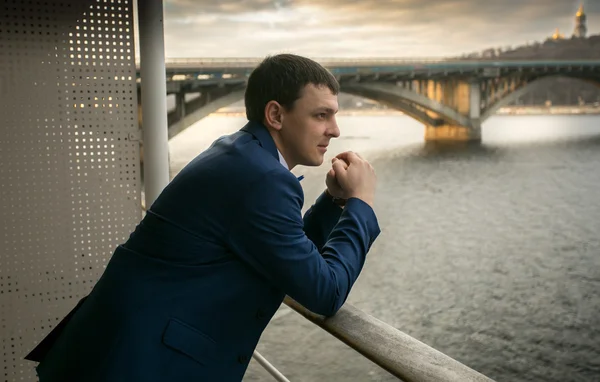 Tonas porträtt av eleganta mannen i kostym ser på floden — Stockfoto
