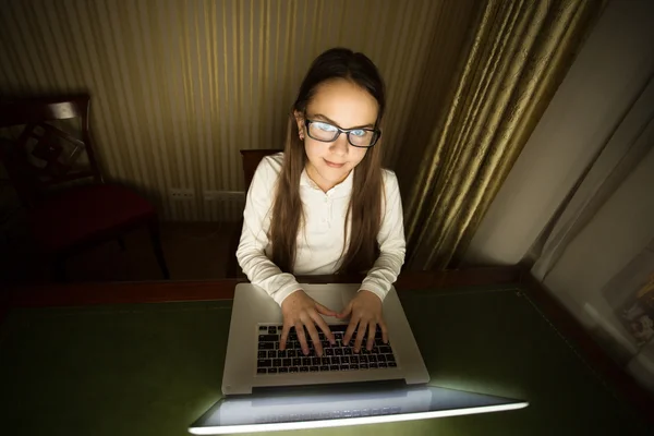 Tiener meisje zit in de donkere kamer met laptop — Stockfoto