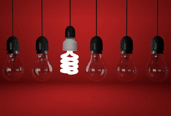 Incandescent and one energy saving bulb on red background — Stock Photo, Image