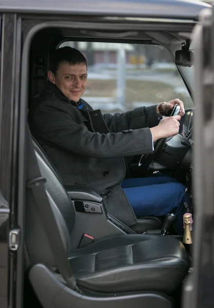 Schöner Geschäftsmann sitzt in luxuriösem Auto — Stockfoto