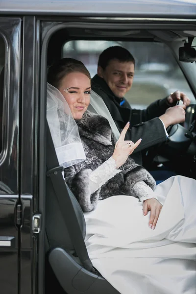 Portrait de mariée heureux et marié posant en voiture — Photo