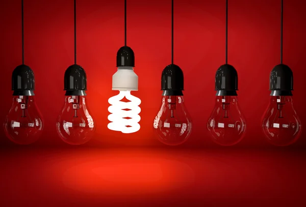 Glowing eco saving bulb hanging on wire in row of incandescent b — Stock Photo, Image