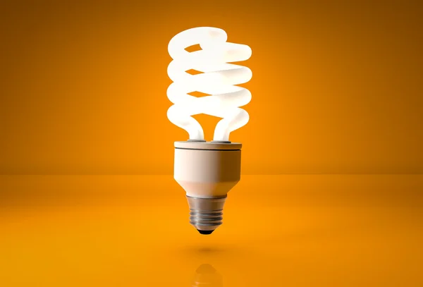 Ampoule à économie d'énergie sur fond orange — Photo