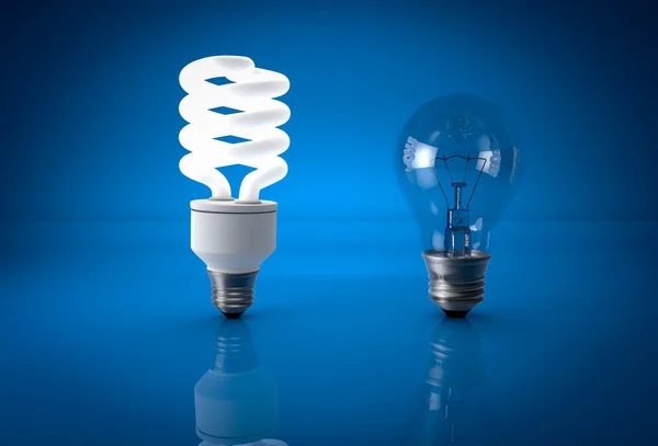 Glowing energy saving bulb and dead incandescent bulb over blueb — Stock Photo, Image