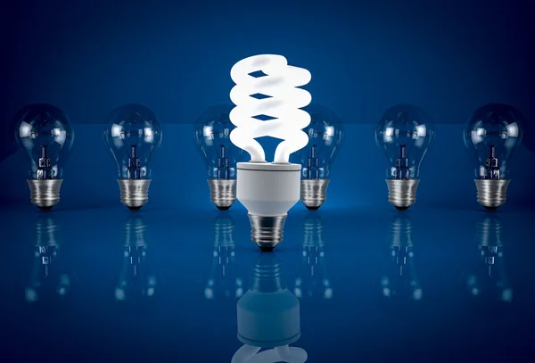 Energy saving bulb among  incandescent bulbs on blue background. — Stock Photo, Image