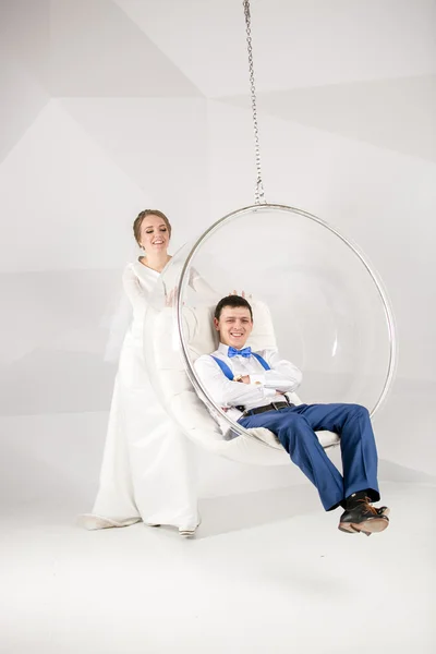 Junge Braut schaukelnder Bräutigam sitzt im Blasenstuhl — Stockfoto