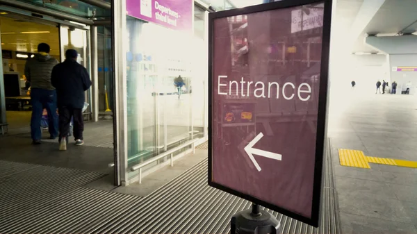 Входной знак в современном аэропорту с автоматическими дверями — стоковое фото