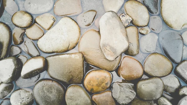 Hintergrund mit bunten Kieseln im Wasser — Stockfoto