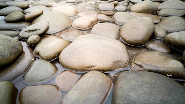 Primer plano de grandes piedras redondas en el río — Foto de Stock