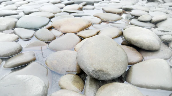 Nahaufnahme von grauen Kieselsteinen, die im Fluss liegen — Stockfoto