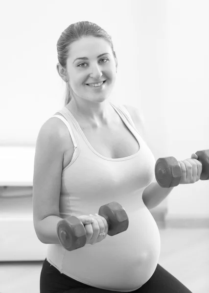 Ritratto in bianco e nero di donna incinta sorridente che esercita wi — Foto Stock