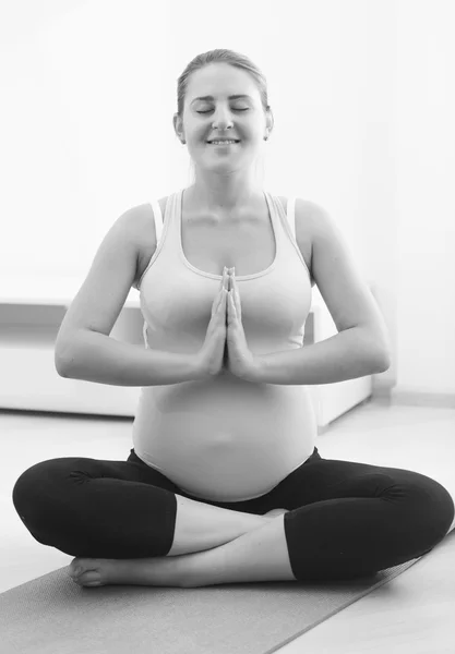 Czarno-białe zdjęcie kobiety w ciąży ćwiczyć jogę w domu — Zdjęcie stockowe