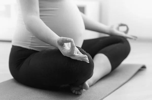 Foto in bianco e nero di una donna incinta che pratica yoga — Foto Stock