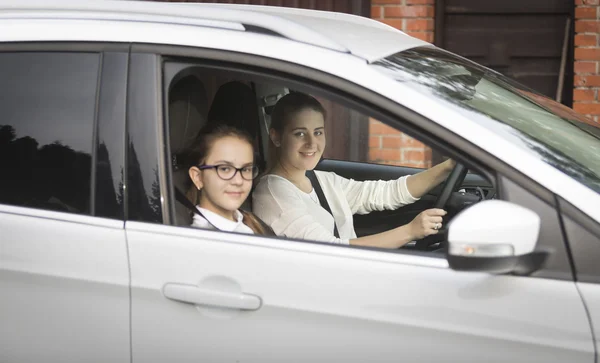 Portret van schoolmeisje met moeder naar school te gaan met de auto — Stockfoto