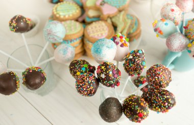 Arka plan bir şekilde dekore edilmiş şeker ve kek ahşap masanın üstüne çıkar