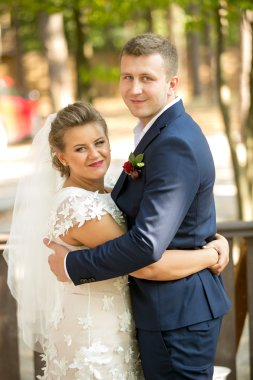 Mutlu yeni evli çift sarılma ve kameraya bakıyor