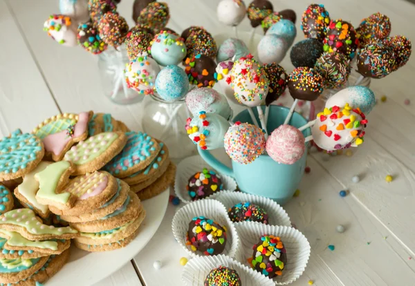 Pastel decorado pops y galletas para Pascua en mesa de madera —  Fotos de Stock