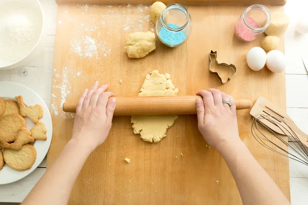 Top view of woman rolling tough for cookies with rolling pin — стоковое фото