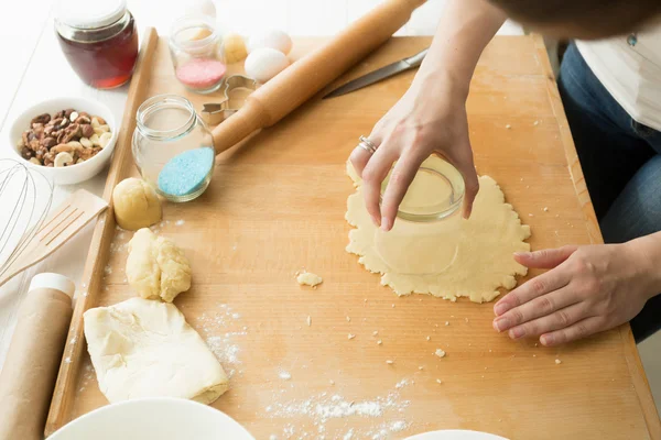 Closeup of young woman cutting dough with glass — Stock Photo, Image