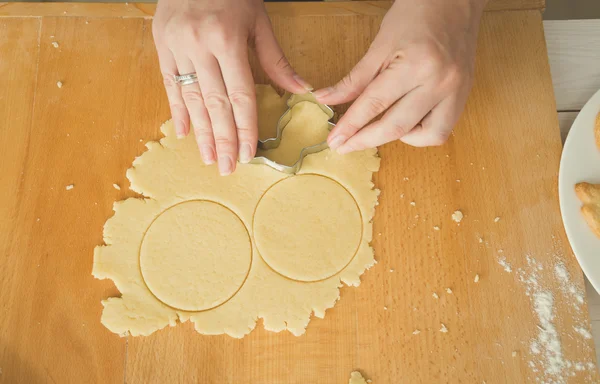 Крупный план женских рук, режущих тесто для печенья — стоковое фото