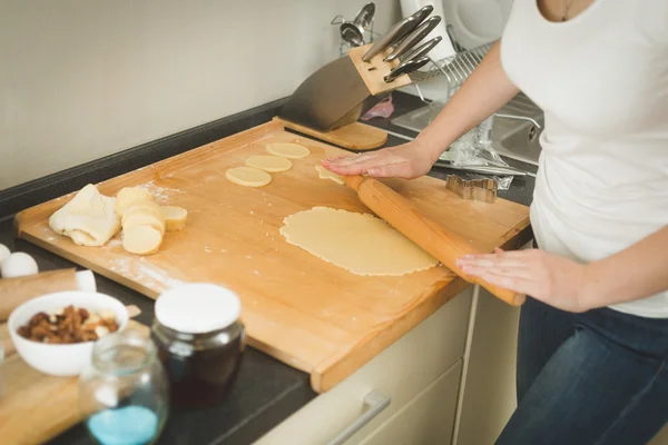 Gros plan de la pâte à rouler jeune femme sur le conseil en bois avec broche — Photo