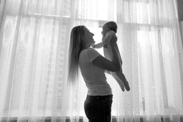 Černá a bílá silueta mladé matky s dítětem — Stock fotografie
