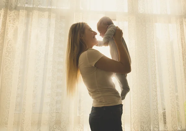 Silhouette tonica di madre felice e piccolo bambino in posa contro — Foto Stock