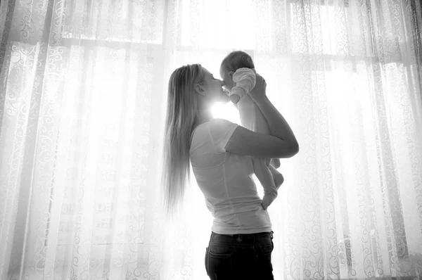 Portrait noir et blanc de mère jouant avec son bébé à côté de — Photo