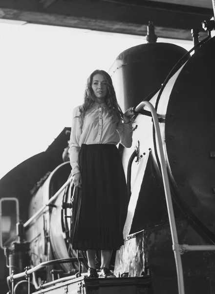 Black and white photo of elegant woman in dress posing on steam — Stock Photo, Image