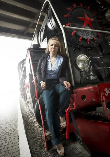 Wanita muda duduk di tangga kereta uap tua — Stok Foto
