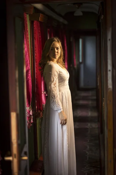 Young woman in vintage dress posing at old train — Stock Photo, Image