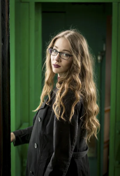 Elegant curly woman wearing eyeglasses posing at old train — Stock Photo, Image