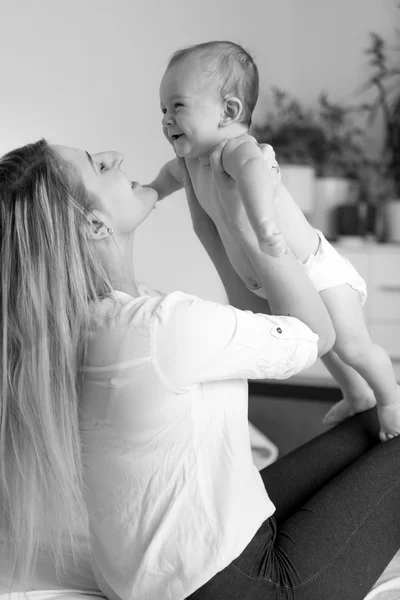 Black and white portrait of happy mother hugging her cheerful ba — Stock Photo, Image