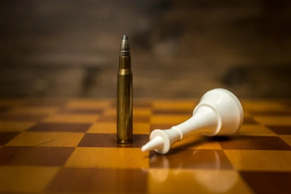 Крупный план пули выигрывает шахматную партию. Понятие оружейной силы — стоковое фото
