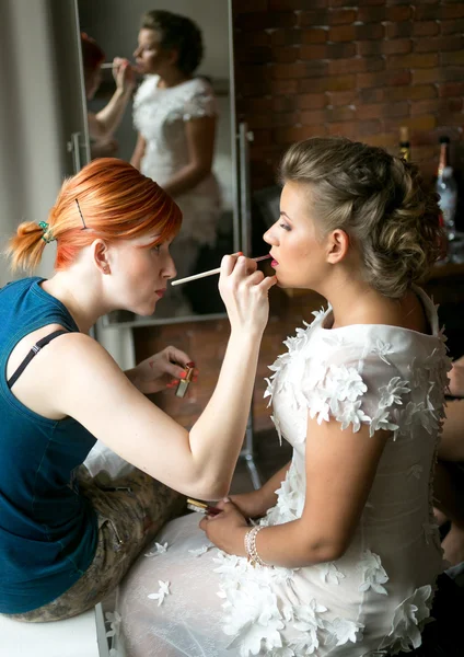 Makeup artist making makeup to beautiful bride at hotel room — Stock Photo, Image